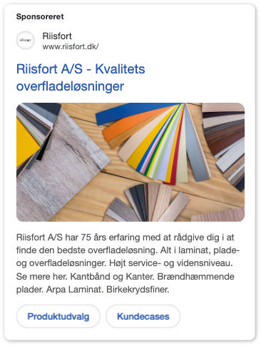 En række farverige og teksturerede laminatprøver er arrangeret som en vifte på en træoverflade. Dette reklamerer for Riisfort A/S, en leverandør af overfladeløsninger.
