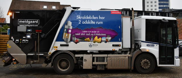 Skraldebil med grafik på, som siger 